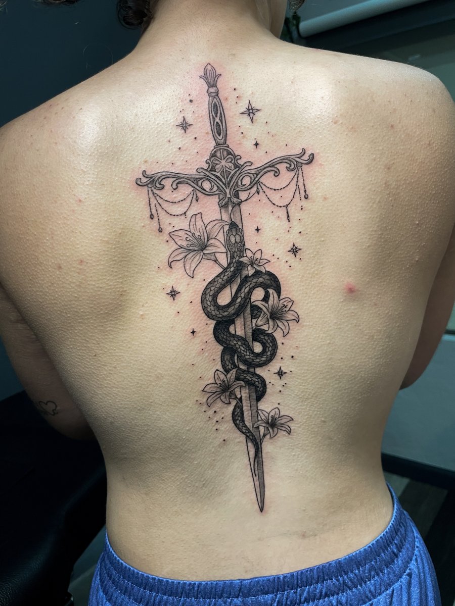 Sword with snake, lilies and stars, spine tattoo by Lindsay, Kustom Tattoo Club