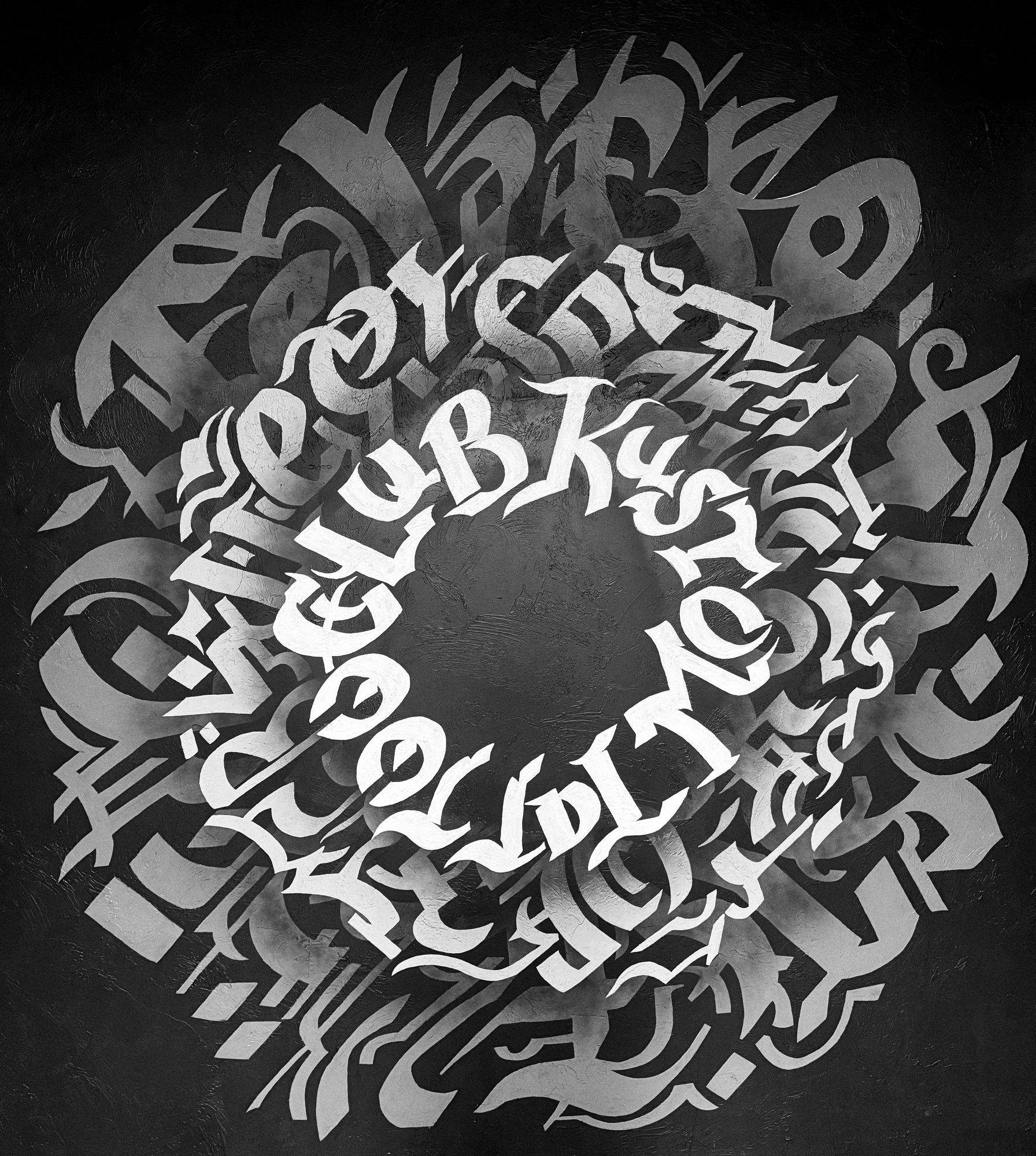 Close-up of the Kustom Tattoo Club calligraphy mural: white and grey blackletter lettering in a circle on a black wall